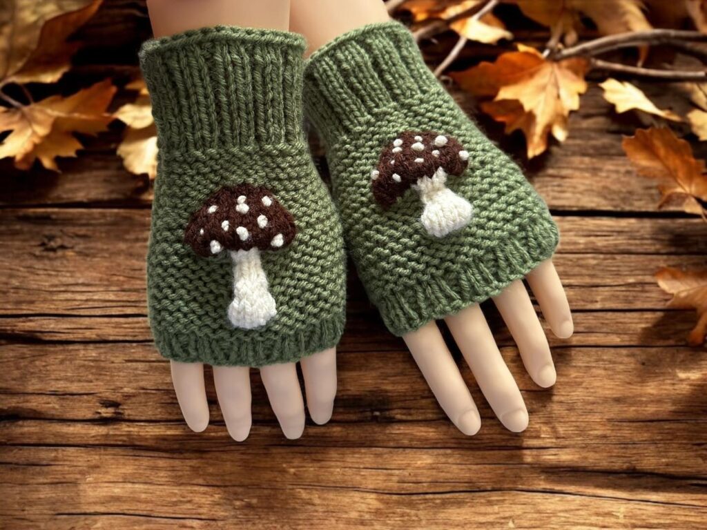 Knitted mushroom-themed fingerless gloves styled with autumn leaves and natural woodland elements."