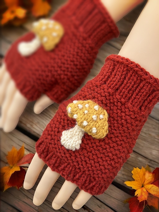 Knitted mushroom-themed fingerless gloves styled with autumn leaves and natural woodland elements."