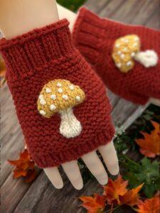 Knitted mushroom-themed fingerless gloves styled with autumn leaves and natural woodland elements."