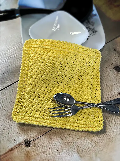 Handmade knit dishcloth pattern with textured stitches and neat border for kitchen use or gifts