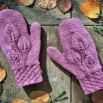 Flat lay photo of knitted leaf mittens made with a free pattern on straight needles