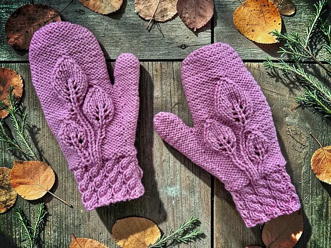 Flat lay photo of knitted leaf mittens made with a free pattern on straight needles