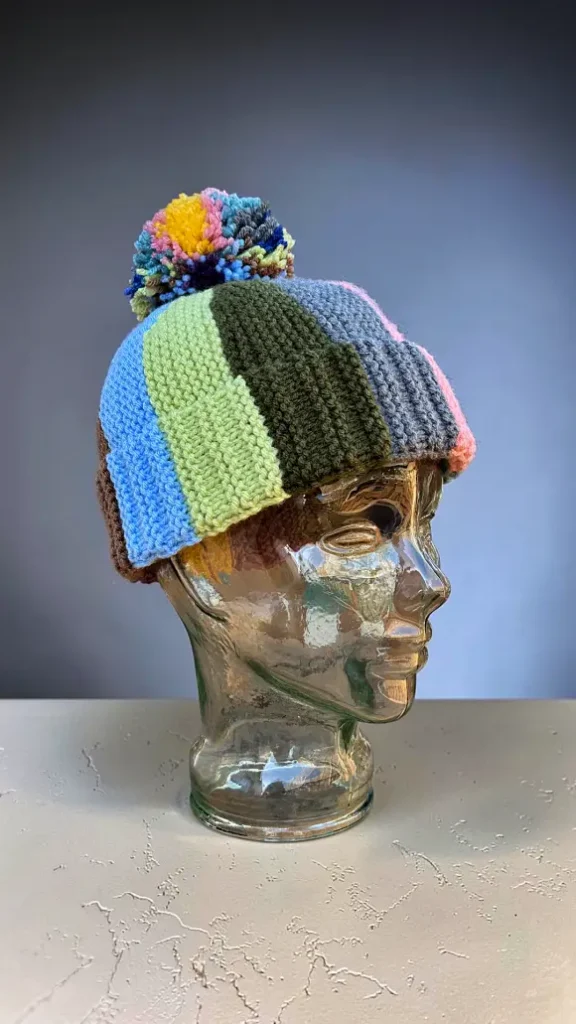 Free scrap yarn bobble beanie knitting pattern shown on glass mannequin head
