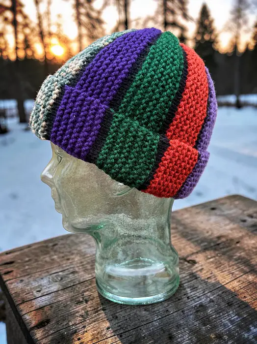 Free knitting pattern Scrap Beanie bobble hat worn on glass mannequin head showing relaxed beanie fit