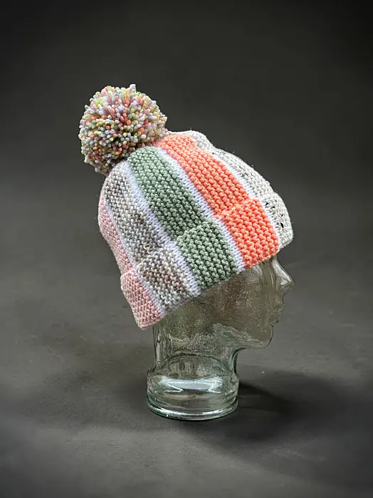 Free knit hat pattern showing Scrap Beanie with textured bobble sections and contrasting colour stripes