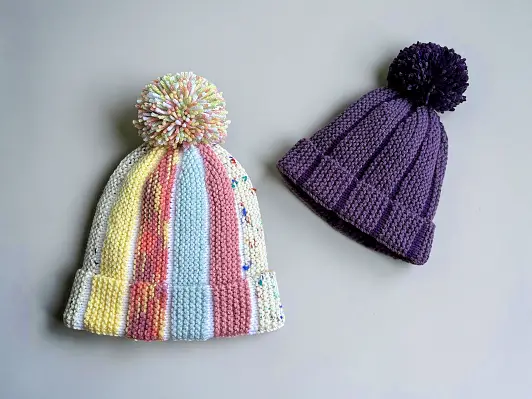Free knitting pattern Scrap Beanie showing bobble beanie style knit flat with scrap yarn and textured colour sections