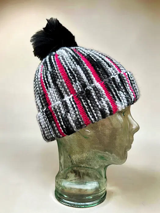 Scrap Beanie knitting pattern on glass mannequin head highlighting texture and two-colour design