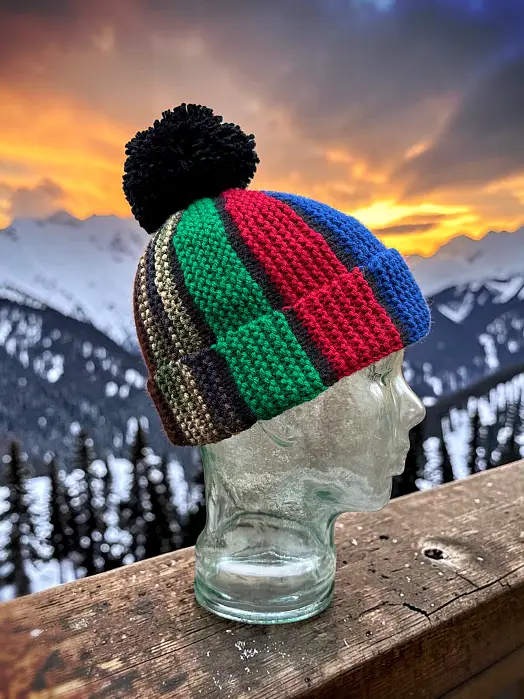Hand knit Scrap Beanie on glass mannequin head featuring scrap yarn colours and textured stitch pattern