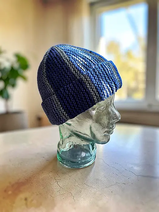 Leftover yarn beanie knitting pattern with mosaic design on a glass