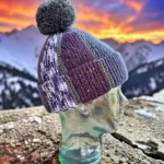 Hand knitted scrap yarn winter hat displayed on a clear glass mannequin head